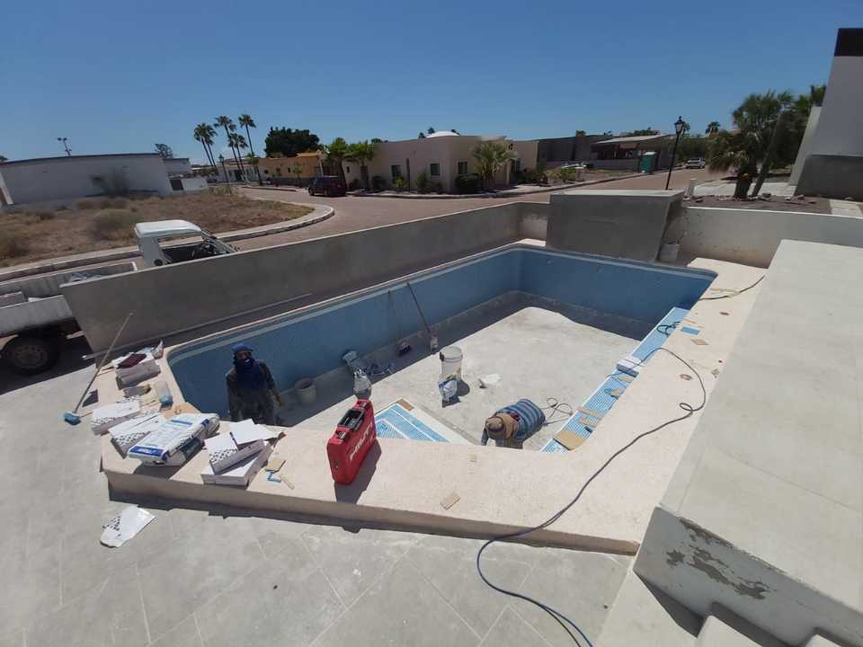 Alberca en obra con material y equipo de instalación